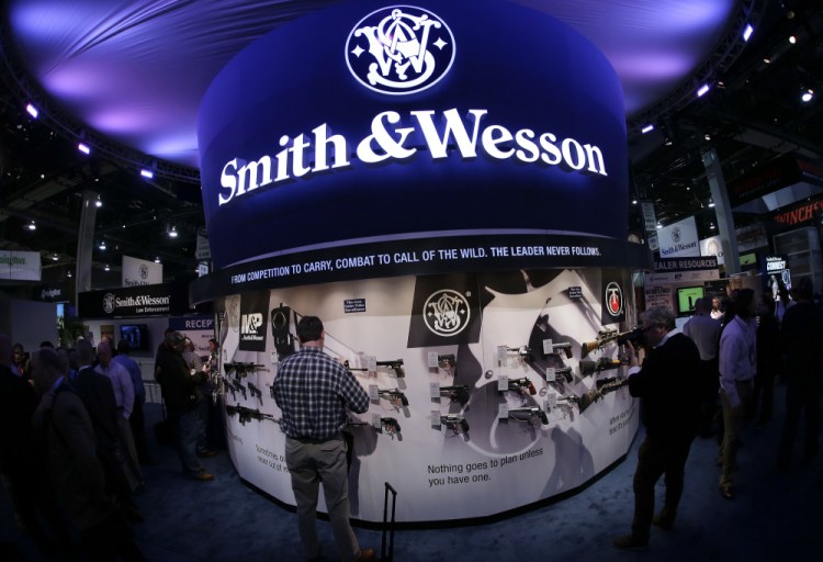 Trade show attendees examine handguns and rifles at the Smith & Wesson display booth in Las Vegas in 2014. Smith & Wesson announced Thursday it plans to move its headquarters from Massachusetts to Tennessee. 