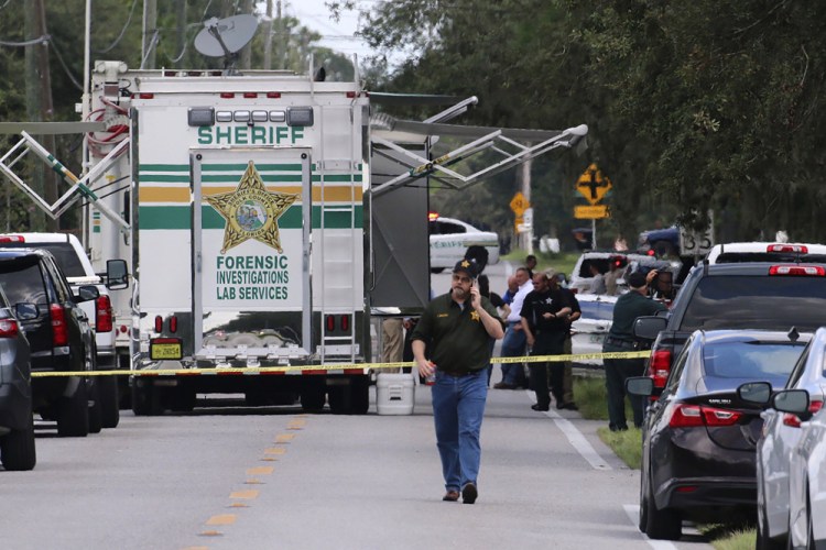 Polk County, Fla., Sheriff's officials work the scene of a multiple fatality shooting Sunday in Lakeland, Fla. 