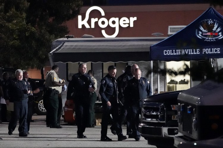 Law enforcement personnel work in front of a Kroger grocery store as an investigation goes into the night following a shooting earlier in the day on Thursday in Collierville, Tenn. Police say a gunman attacked people in the store and killed at least one person and wounded 12 others before the suspect was found dead.