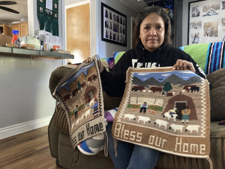 Seraphine Warren of Tooele, Utah, holds  a rug made by her aunt, Navajo rug weaver Ella Mae Begay. Begay, 62, disappeared in June, one of thousands of missing Indigenous women across the U.S. (AP Photo/Lindsay Whitehurst)