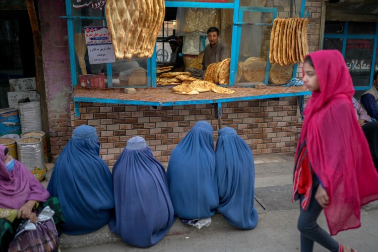 Burqa-clad women wait for free bread in front of a bakery in Kabul, Afghanistan, on September 16, 2021. (Bulent Kilic/AFP/Getty Images/TNS)