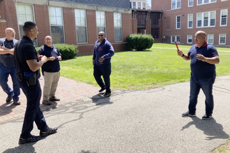 In this July 28, 2021 photo, Jose Otero from the New York City Police Department, right, holds a plastic knife after completion of a role-playing scenario in which New England police officers were learning de-escalation techniques from the Police Executive Research Forum in Saco, Maine. (AP Photo/David Sharp)