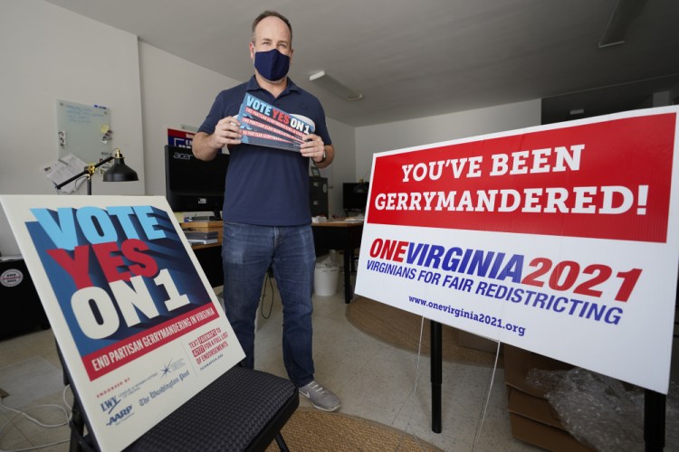 Redistricting reform advocate Brian Cannon poses with some of his yard signs and bumper stickers in his office in Richmond, Va., in 2020. A new voter-approved commission in Ohio that was supposed to reduce partisanship in the once-a-decade process of political map-drawing has already become a flop.