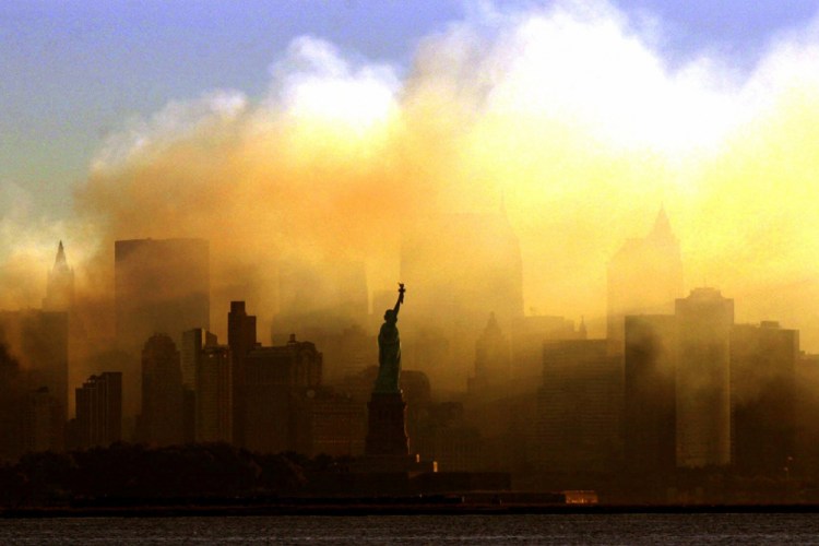 The Statue of Liberty stands in front of a smoldering lower Manhattan at dawn, seen from Jersey City, N.J., on Sept. 15, 2001.