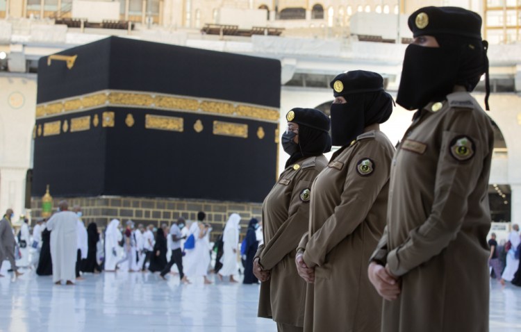 Saudi police women, who were recently deployed to the service, from right to left, Samar, Alaa, and Bashair, stand alert in front of the Kaaba, the cubic building at the Grand Mosque, during the annual hajj pilgrimage July 20 in the Saudi Arabia's holy city of Mecca.