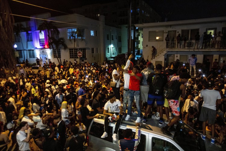 Crowds defiantly gather March 21 in the street while a speaker blasts music an hour past curfew in Miami Beach, Fla. 

