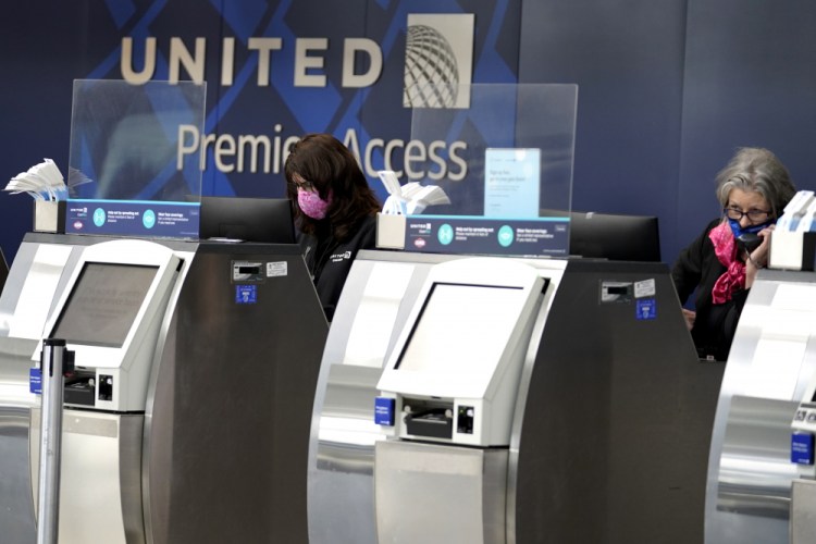 United Airlines employees work at ticket counters in Terminal 1 at O'Hare International Airport in Chicago on Oct. 14, 2020.  