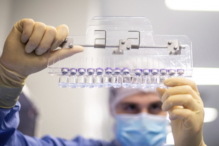 A technician inspects filled vials of the Pfizer-BioNTech COVID-19 vaccine at the company's facility in Puurs, Belgium in March. 