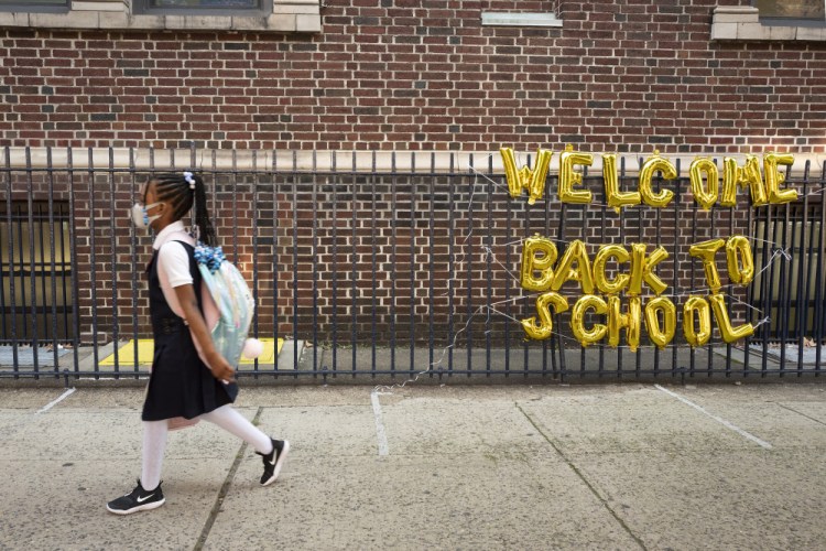 A girl passes a "Welcome Back to School" sign on Sept. 13 as she arrives for the first day of class at Brooklyn's PS 245 elementary school in New York.