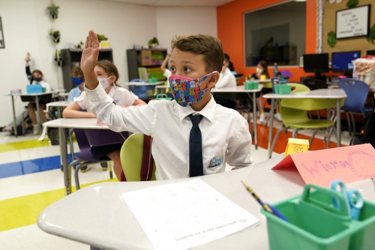 Student Winston Wallace, 9, raises his hand in class at iPrep Academy on the first day of school Aug. 23 in Miami.