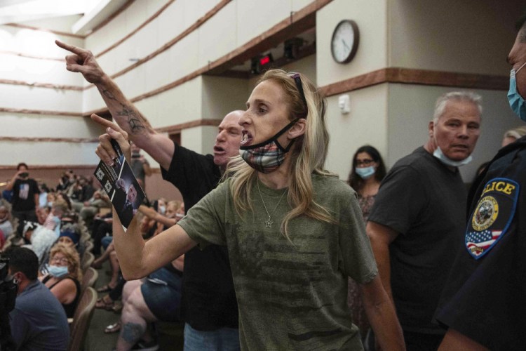 Protesters against a COVID-19 mask mandate gesture as they are escorted out of a Clark County School Board meeting at the Clark County Government Center in Las Vegas in August. 