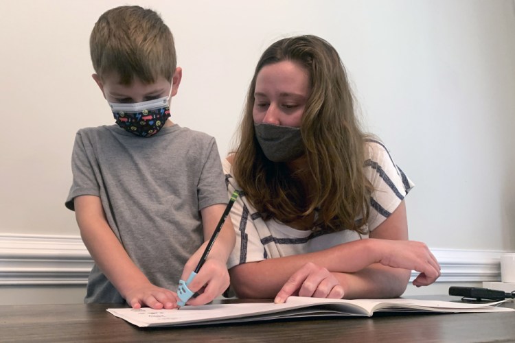 Emily Goss goes over schoolwork at the kitchen table with her 5-year-old son at their Monroe, N.C., home on Monday. The Gosses have decided to home-school Berkeley after the Union County school district chose not to implement a mask mandate for children.