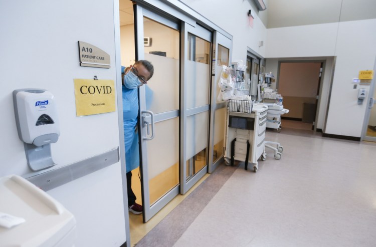 A nurse sticks her head out of a room of a COVID-19 patient in the CoxHealth Emergency Department on July 16 in Springfield, Mo. 