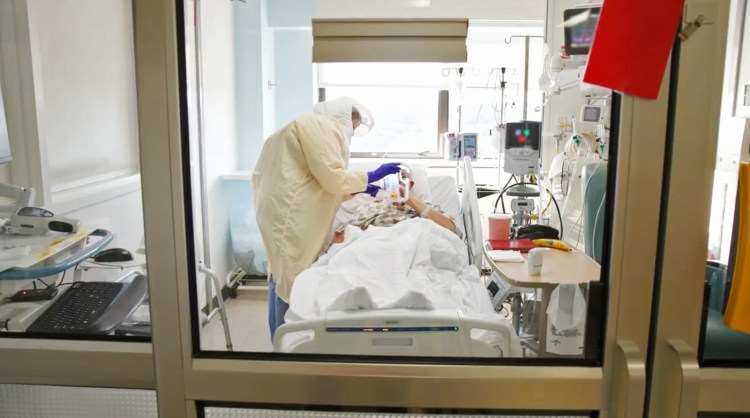 In this image taken from a Maine Medical Center video posted on its Facebook page on Sept. 3, an ICU nurse cares for a COVID-19 patient at Maine Medical Center in Portland.