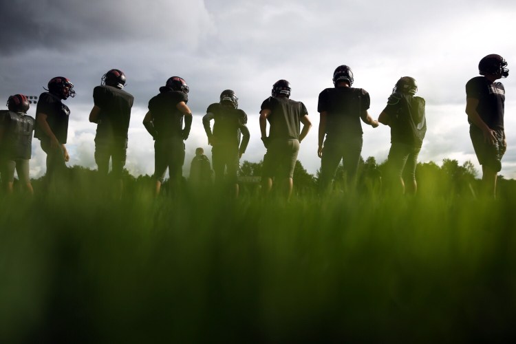 Members of the Brunswick High football wait on the sideline between practice drills on Thursday. School officials have investigated an alleged hazing incident involving football players during an overnight retreat in August. Some players have been removed from the team by the school's superintendent.