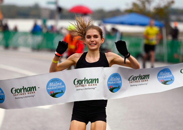 Abby Hamilton of Yarmouth crosses the finish line as the top women's finisher in the Maine Marathon on Sunday in Portland.
