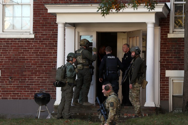 Police enter the apartment building at 62 State St. in Portland on Sunday.