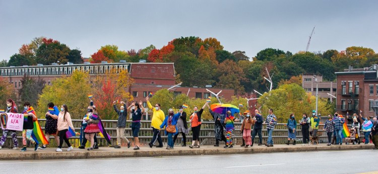 About 50 people march across Longley Memorial Bridge over the Androscoggin River during Saturday morning's L/A Pride March. After gathering at Festival Plaza in Auburn, the group marched to Simard Payne Memorial Park in Lewiston where this year's theme was "Out and Spooky" and was a celebration of National Coming Out Day.
