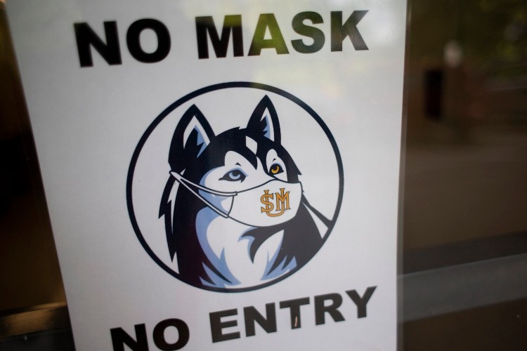 Signs at the entrances to buildings on the University of Southern Maine’s Gorham campus remind visitors to wear masks. 