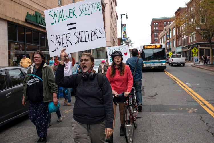 Jess Falero marches down Congress Street in Portland on Sunday with a handful of other activists and supporters as a part of a day's worth of events commemorating World Homeless Day.