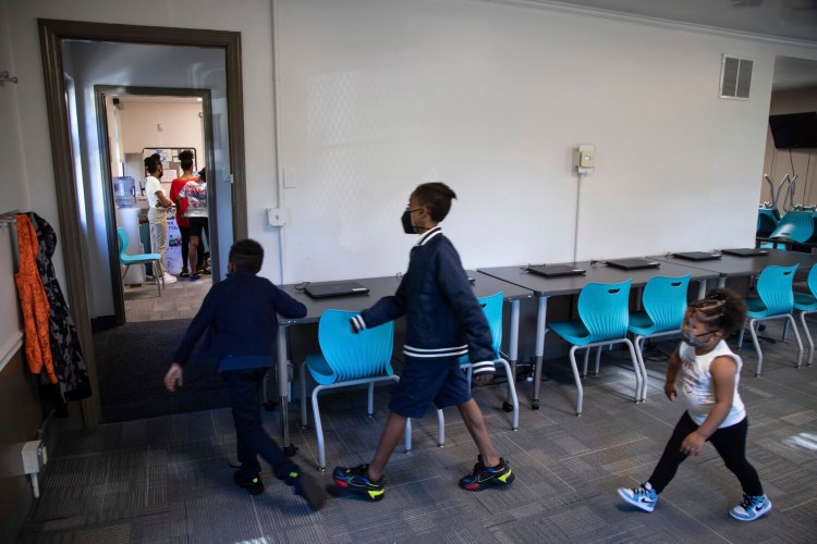 In this Friday, Oct. 1, 2021 photo, from left, Zihare Wellons, 7, Shahif Wellons, 12, and Janiyah Acie, 3 walk through new Rec2Tech space at Jefferson Recreation Center, which will provide access to technology and innovative programming for community members including STEM, computer science and coding education, combined with the arts in Pittsburgh. The city plans to use some of the money from the American Rescue Plan, passed by Congress last spring, to continue expanding these programs. Initial programming will be for young people, with plans to grow the programming into the broader community. (AP Photo/Rebecca Droke)