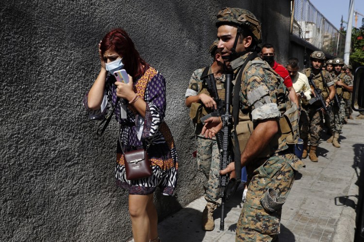 Lebanese army special forces soldiers protect teachers as they flee their school after deadly clashes erupted Thursday along a former 1975-90 civil war front-line between Muslim Shiite and Christian areas, at Ain el-Remaneh neighborhood, in Beirut, Lebanon.