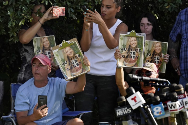 Supporters of Gabby Petito hold up photos of Gabby after a news conference Wednesday in North Port, Fla. Items believed to belong to Brian Laundrie and potential human remains were found in a Florida wilderness park during a search for clues in the slaying of Gabby Petito. 