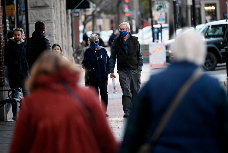Pedestrians walk along crowded Commercial Street in Portland on Thursday.