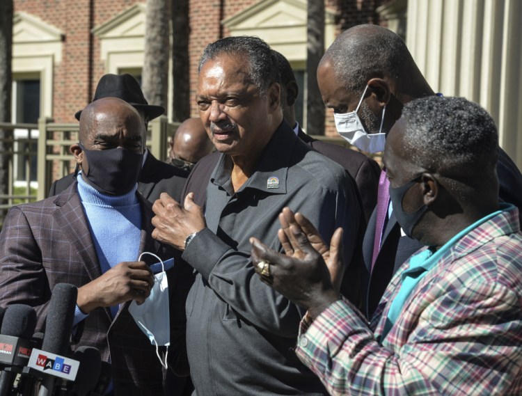 The Rev. Jesse Jackson enters the Glynn County Courthouse in Brunswick, Ga. on Monday, when he attended the morning session of the trial of three men accused of murder in the death of Ahmaud Arbery. Marcus Arbery, the father of slain jogger Ahmaud Arbery, applauds as Jackson speaks.