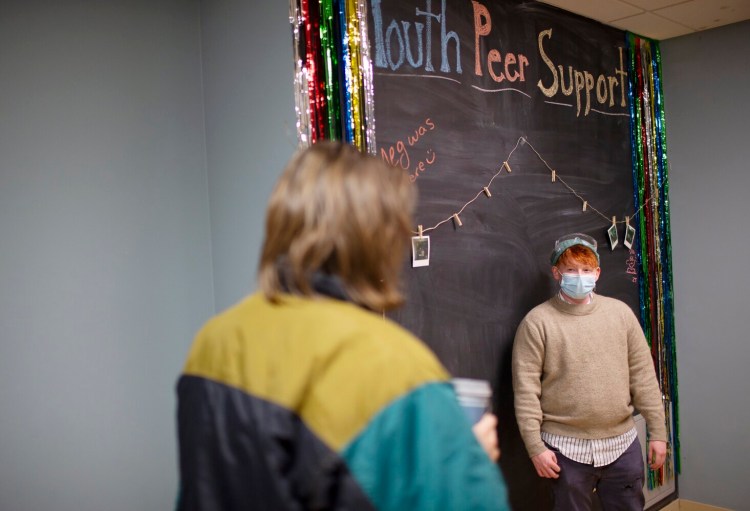PORTLAND, ME - DECEMBER 14: Asher Havlin, supervisor of the Youth Peer Support Statewide Network, talks to a guest (***who wished to not be identified***) at Maine Behavioral Healthcare peer support center open house. (Photo by Derek Davis/Staff Photographer)