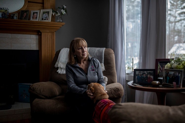 Catherine Ryder pets her son Colin Gallagher’s therapy dog, Doe, at her home in Windham on Wednesday. Colin Gallagher, who was 35, died Dec. 21 of an overdose. A photo of him sits above her on the mantel.