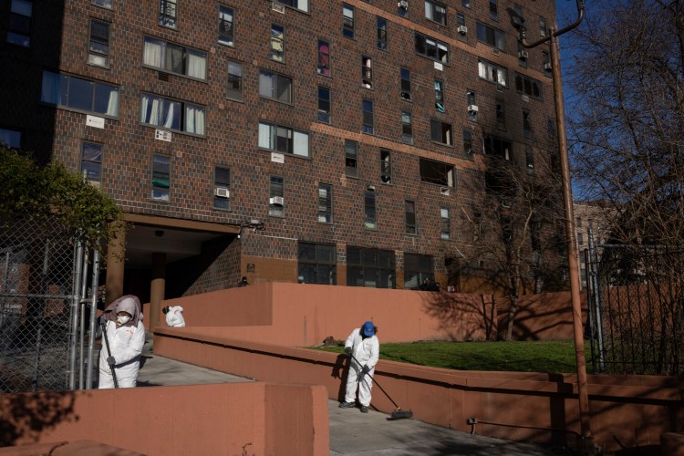 Cleaning and recovery crews work outside the fire-damaged apartment building in the Bronx on Monday in New York. Several people were still in critical condition this week after a malfunctioning space heater sparked the city’s deadliest fire in three decades on Sunday.