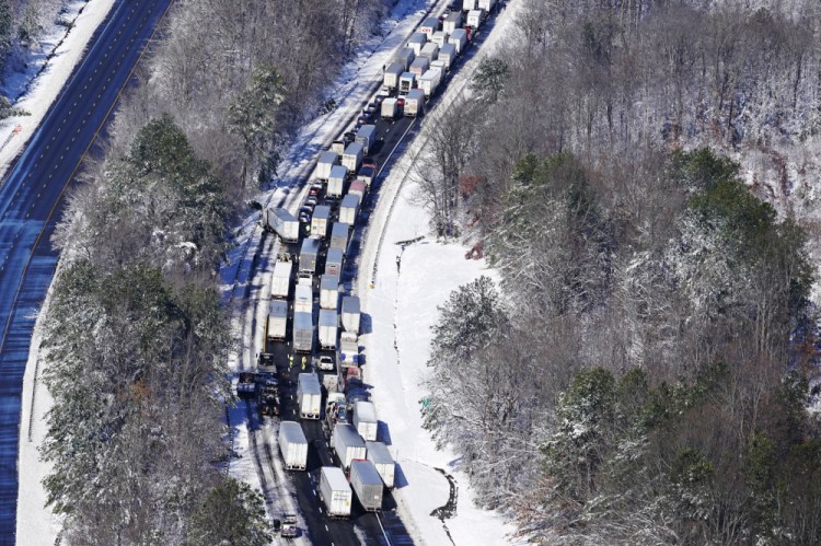 Drivers wait for the traffic to be cleared as cars and trucks are stranded on sections of Interstate 95 on Tuesday in Carmel Church, Va. Close to 48 miles of the Interstate was closed due to ice and snow. 