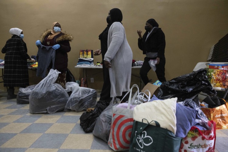 People prepare donations at the Gambian Youth Organization near the apartment building where a fire killed 17 in the Bronx, on Monday in New York. 