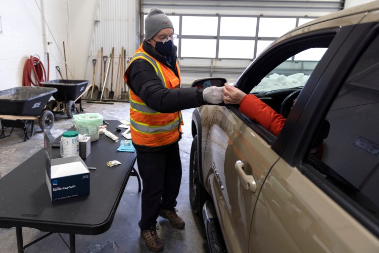 Tom Downing hands a driver the swab from a rapid COVID-19 test so they can self-administer in their car at Yarmouth Public Works on Monday. The free testing is held every Monday morning from 8-10, staffed by volunteers from the Yarmouth COVID Task Force.