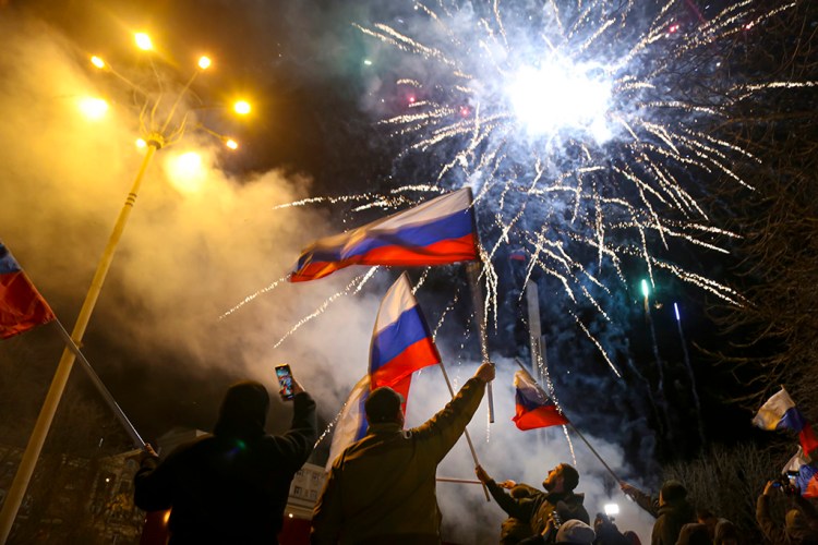 People wave Russian national flags late Monday celebrating the recognition of independence in the center of Donetsk, the territory controlled by pro-Russian militants in eastern Ukraine.