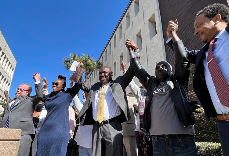 CORRECTS SPELLING OF AHMAUD ARBERY'S LAST NAME - The family and attorneys of Ahmaud Arbery raise their arms in victory outside the federal courthouse in Brunswick, Ga., after all three men involved in his killing were found guilty of hate crimes, Tuesday, Feb. 22, 2022. Greg McMichael, Travis McMichael and William “Roddie” Bryan were found guilty of violating Arbery’s civil rights and targeting him because he was Black. (AP Photo/Lewis M. Levine)