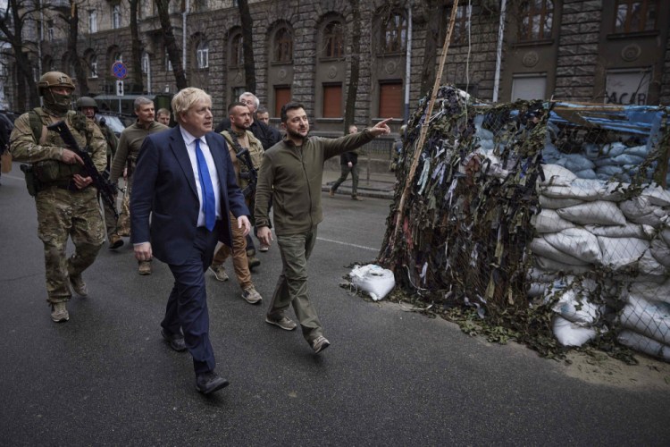 Ukrainian President Volodymyr Zelensky, center, and Britain's Prime Minister Boris Johnson, center left, walk in downtown Kyiv, Ukraine, on Saturday.