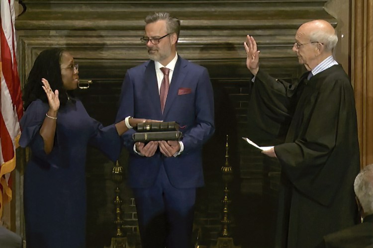 Retired Supreme Court Associate Justice Stephen Breyer administers the Judicial Oath to Ketanji Brown Jackson as her husband Patrick Jackson holds the Bible on Thursday at the Supreme Court in Washington.