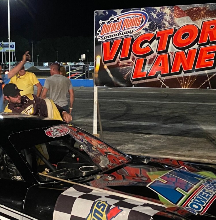 Driver DJ Shaw climbs out of his car after winning the Pro All Stars Series race on Saturday night at Oxford Plains Speedway.