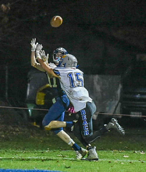 Dirigo’s Trent Holman and OOB’s Shiloh Thao stretch for an incomplete pass intended for Holman during Friday nights game in Dixfield.