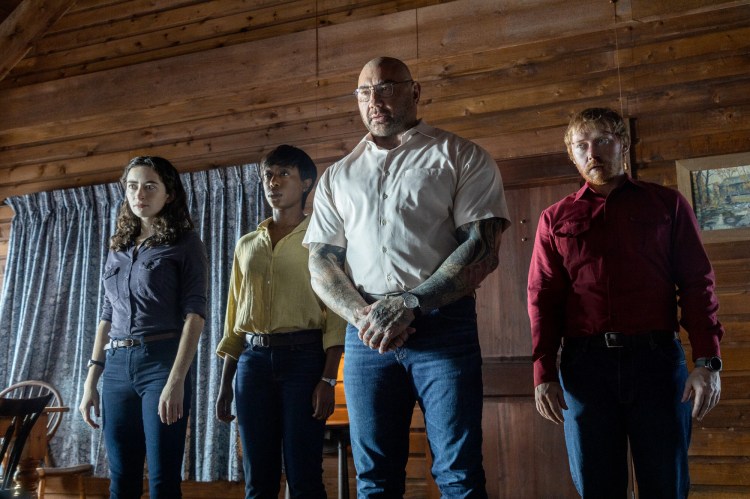 From left: Abby Quinn, Nikki Amuka-Bird, Dave Bautista and Rupert Grint in "Knock at the Cabin." MUST CREDIT: Universal Pictures/PhoByMo