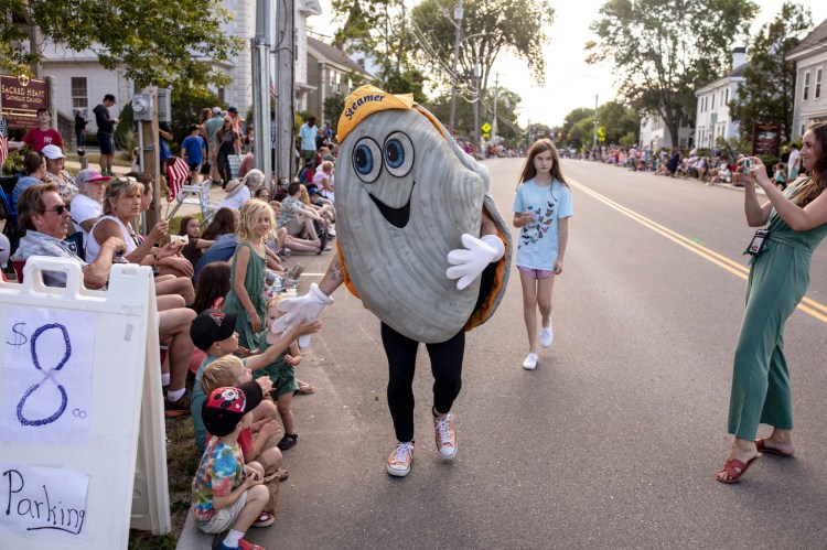Steamer the Clam high fives parade-goers during the 2022 Yarmouth Clam Festival parade.