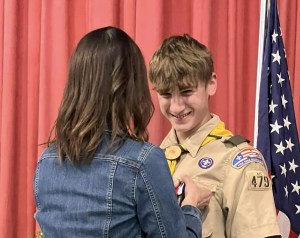 Nathan and Lee: Nathan receives the Eagle Scout Charge from Lee Pettengill who is the Chartered Organization Representative for Troop 479 and served as Master of Ceremonies for the Eagle Court of Honor Ceremony. Nathan: Nathan Choate, Eagle Scout, makes the Scout Sign during his Eagle Scout Ceremony Stephanie pins Nathan: Stephanie Drake Choate pins the Eagle Scout medal onto her son's uniform. "It was so special to have it at Mount Merici Academy. We are so proud of you, Nathan," she said. Joe and Nathan: Joe Doore of the Town of Albion spoke about why Nathan received the Spirit of America Award from the Town of Albion earlier this year. Elijay Parish Lovejoy was born in Albion in 1802 and was an American newspaper editor who was killed by a mob for his firm, published positions denouncing slavery in 1837. Nathan's Eagle Scout Project restored the marker in Albion commemorating Lovejoy.