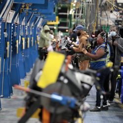 Employees work on the assembly line at the Dakkota Integrated Systems manufacturing facility in Detroit, Michigan, U.S., on Thursday, May 5, 2022.