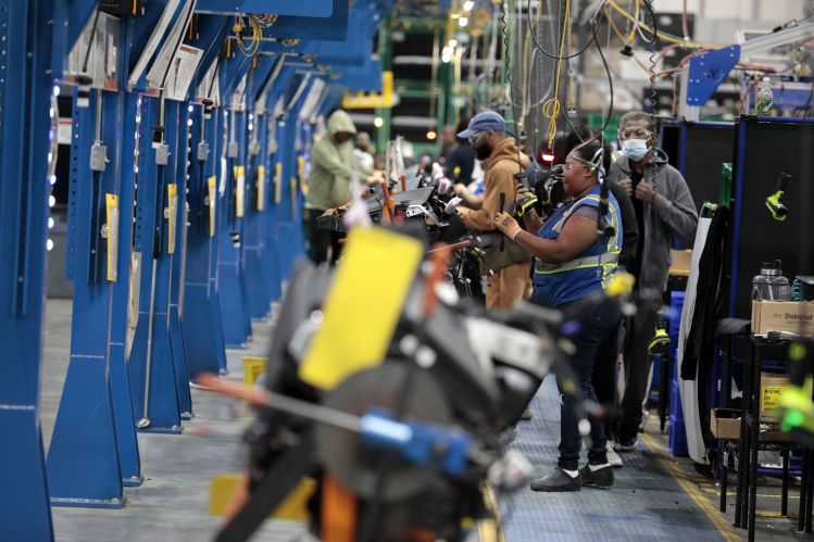 Employees work on the assembly line at the Dakkota Integrated Systems manufacturing facility in Detroit, Michigan, U.S., on Thursday, May 5, 2022.