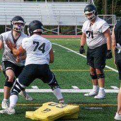 Offensive line coach Mike Deitrick watches junior Ethan Ecsedy participate in a blocking drill on Thursday, Aug. 22, 2024.