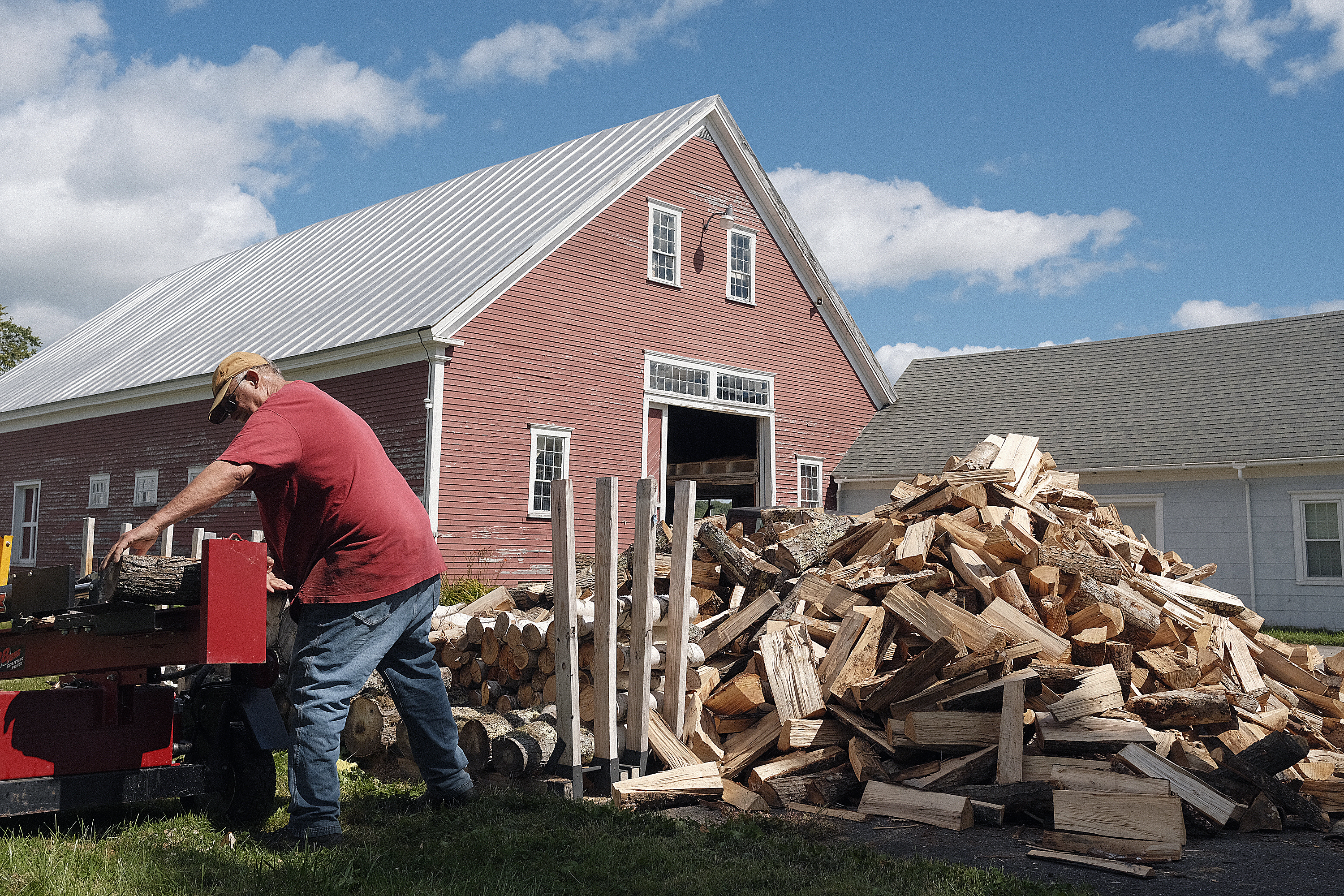 Eric Boyd splits a 8, 2024 wood while topping off piles of the fuel in the yard of his Monmouth farmhouse. Boyd anticipates burning eight cord this winter with a wood fired boiler providing the primary heat for the home.