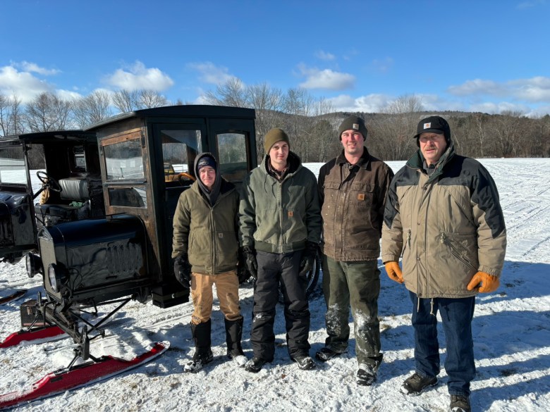 family stands next to snowmobile